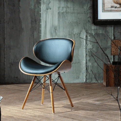 A Black Chair With Wooden Legs Is Sitting On A Wooden Floor GIF