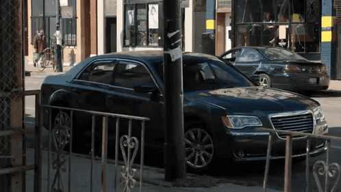 A Black Chrysler Car Is Parked On The Side Of The Street GIF