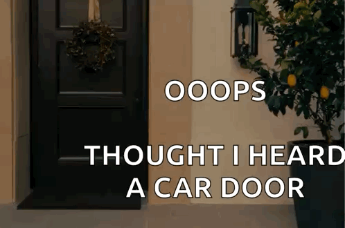 a black door with a wreath on it and the words oops thought i heard a car door below it