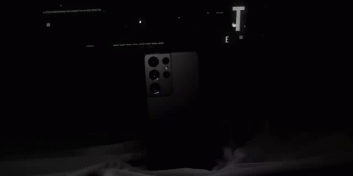 A Black Galaxy S21 Ultra Phone Is Sitting On A Table . GIF
