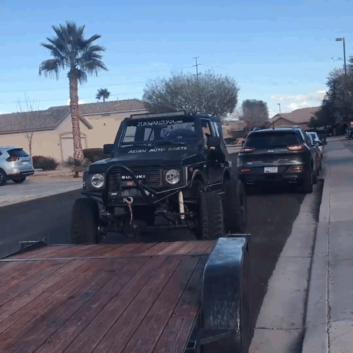 A Black Jeep With Asian Auto Parts On The Windshield GIF