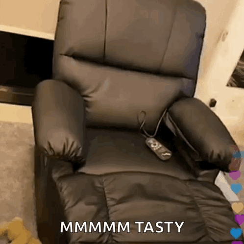 A Black Leather Recliner With A Remote Control And The Words Mmmm Tasty On It GIF