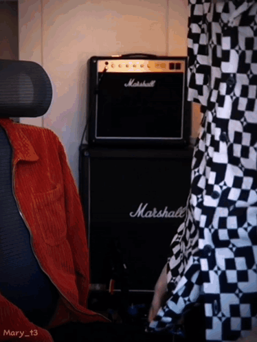 A Black Marshall Amplifier Sits In Front Of A Person GIF
