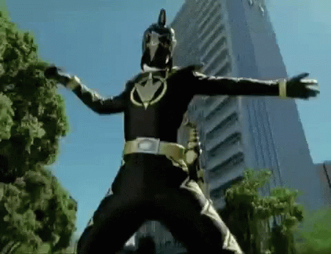 A Black Power Ranger Is Standing In Front Of A Tall Building . GIF