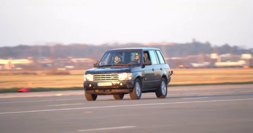 A Black Range Rover Is Driving Down A Road With A License Plate That Says Jc - Nc - 88 GIF