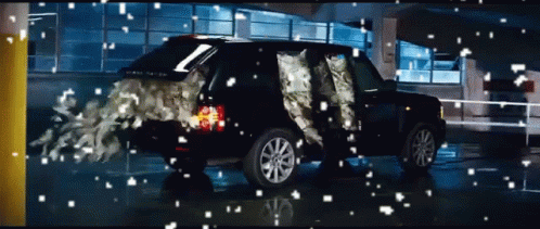 A Black Range Rover Is In A Parking Garage With Snow Falling On It GIF