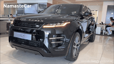 A Black Range Rover Sits In A Showroom GIF
