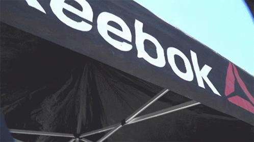 A Black Reebok Tent With A White Logo On It GIF