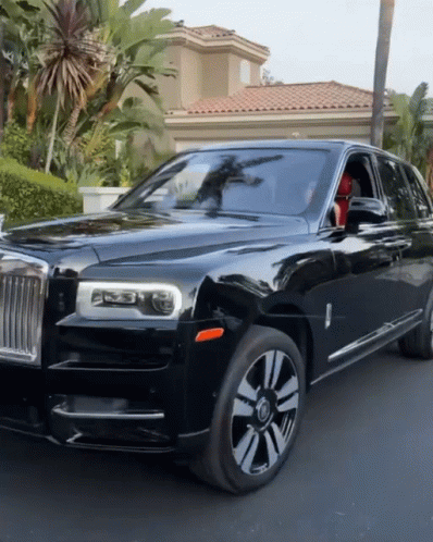A Black Rolls Royce Is Parked On The Side Of The Road GIF