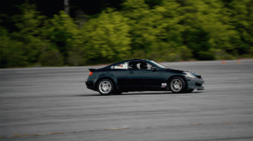 A Black Sports Car Is Driving Down A Road With A Sticker On The Side That Says ' Rs ' GIF