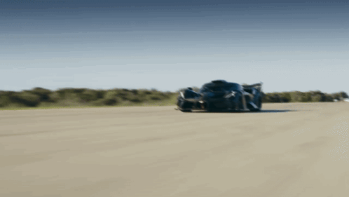 a black sports car is driving down a track