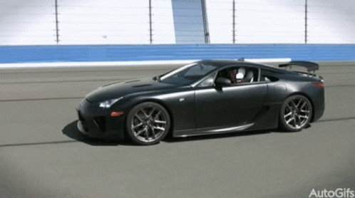 A Black Sports Car Is Driving On A Track With Autogifs Written In The Corner GIF