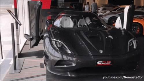 A Black Sports Car Is Parked In A Showroom With A Youtube.com Link GIF
