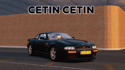 A Black Sports Car Is Parked In Front Of A Brick Wall With The Words Cetin Cetin Written Above It GIF