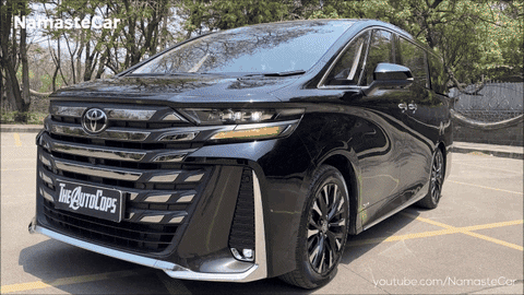 A Black Toyota Minivan Is Parked In A Parking Lot With Trees In The Background GIF