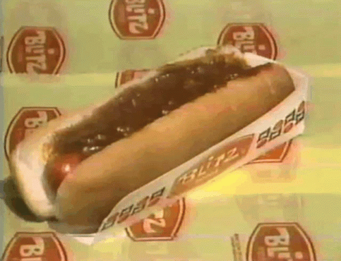 a blitz hot dog is sitting on a yellow surface