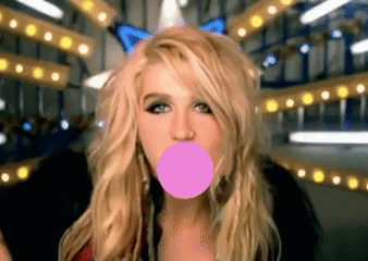 A Blonde Woman Blowing A Pink Bubble With A Butterfly In The Background GIF
