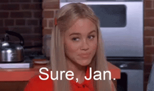 A Blonde Woman Is Sitting In A Kitchen With The Words `` Sure , Jan . '' Written On Her Face . GIF