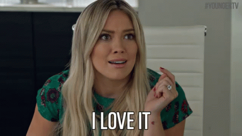 A Blonde Woman Says I Love It In A Green Shirt GIF