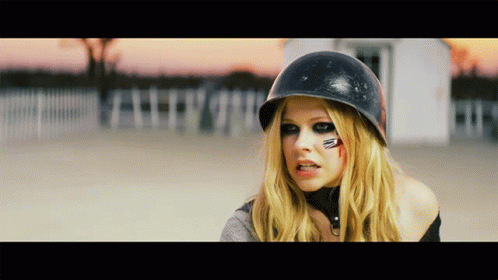 A Blonde Woman Wearing A Black Helmet Has A Red Circle On Her Face GIF