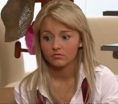 A Blonde Woman Wearing A White Shirt And A Red Tie Is Looking At The Camera . GIF