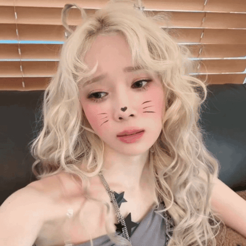 A Blonde Woman With A Cat Face Painted On Her Face GIF