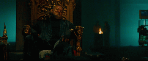 a bloody hand is reaching out towards a man sitting in a chair