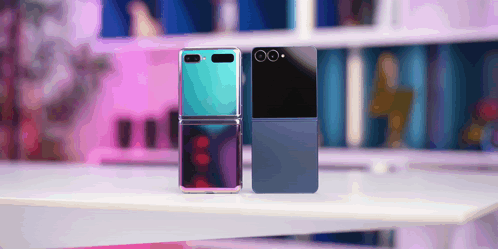 A Blue And A Black Flip Phone Are Sitting On A Table GIF