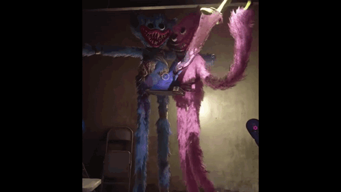 A Blue And Pink Stuffed Animal Are Standing Next To Each Other In A Room . GIF