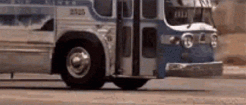 A Blue And White Bus Is Driving Down A Street . GIF