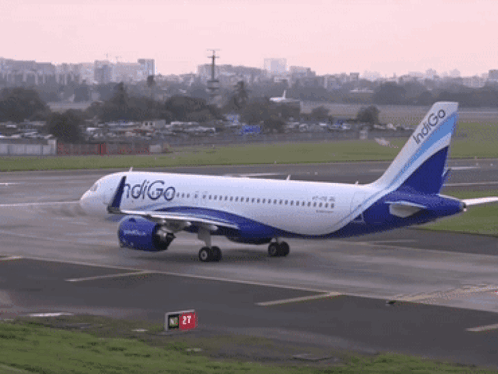 A Blue And White Indigo Airplane Is Taking Off From An Airport Runway GIF