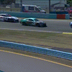 A Blue And White Race Car Is Driving Down A Track . GIF