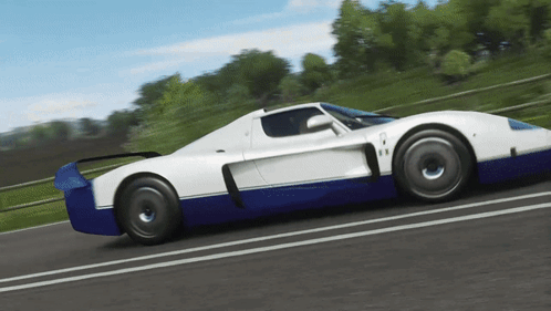 A Blue And White Sports Car Is Driving Down The Road GIF