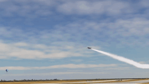 A Blue And Yellow Jet Is Flying Through A Blue Sky GIF