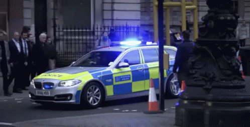 A Blue And Yellow Police Car With A License Plate That Says E916 H00 GIF