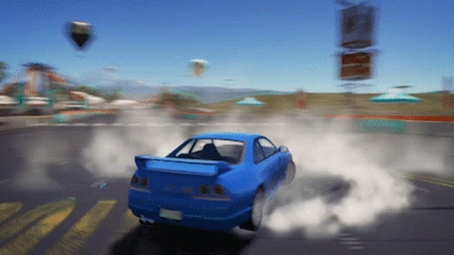 A Blue Car Is Driving Down A Road With Smoke Coming Out Of The Tire GIF