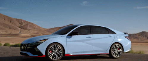 A Blue Car Is Parked On The Side Of A Road GIF