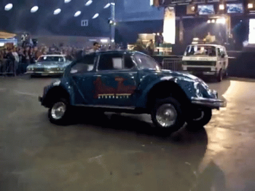 A Blue Car With A Sticker On The Side That Says Volkswagen GIF