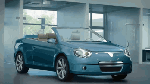 A Blue Convertible Is Parked In A Garage GIF