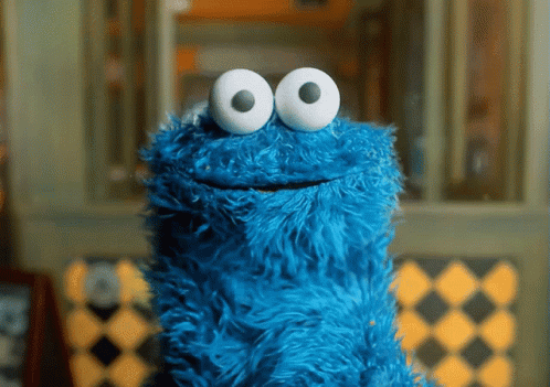 A Blue Cookie Monster With White Eyes Is Smiling GIF