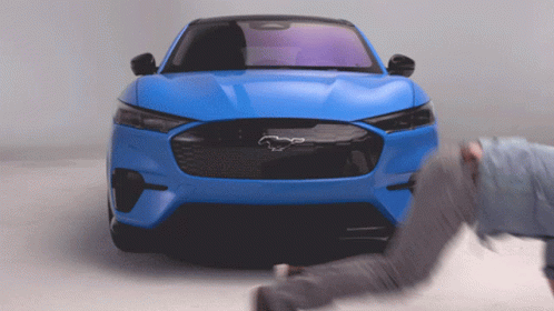 A Blue Ford Mustang With A Black Horse On The Front GIF