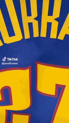 A Blue Jersey With Yellow Letters That Says Murray 27 GIF