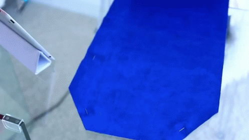 A Blue Piece Of Fabric Is Pinned To A Glass Surface GIF