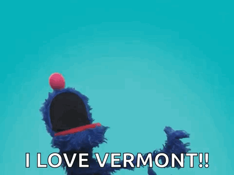 A Blue Puppet With A Red Ball On Its Head Is Saying I Love Vermont ! GIF