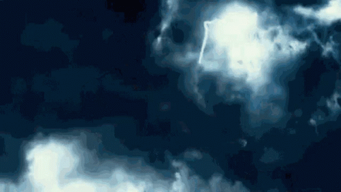 A Blue Sky With White Clouds And A Lightning Strike GIF