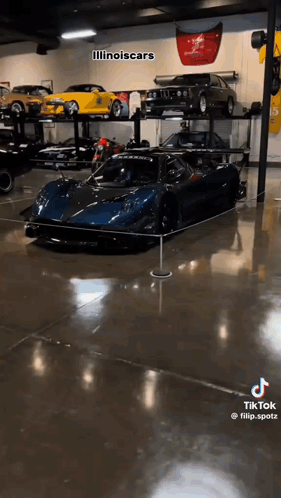 A Blue Sports Car Is Displayed In A Garage . GIF