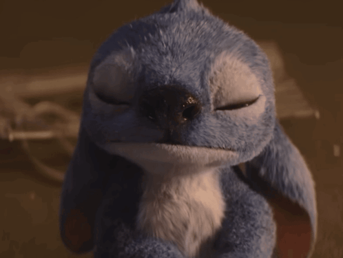 A Blue Stuffed Animal With Its Eyes Closed Looks Like A Bird GIF