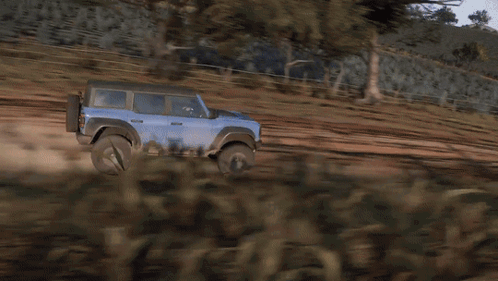 A Blue Suv Is Driving On A Dirt Road GIF
