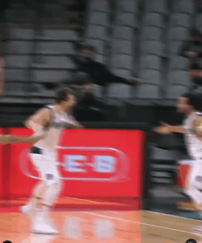 A Blurred Image Of A Basketball Game With A Red Sign That Says Es GIF