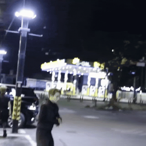 A Blurred Image Of A Carnival At Night With A Carousel In The Background GIF